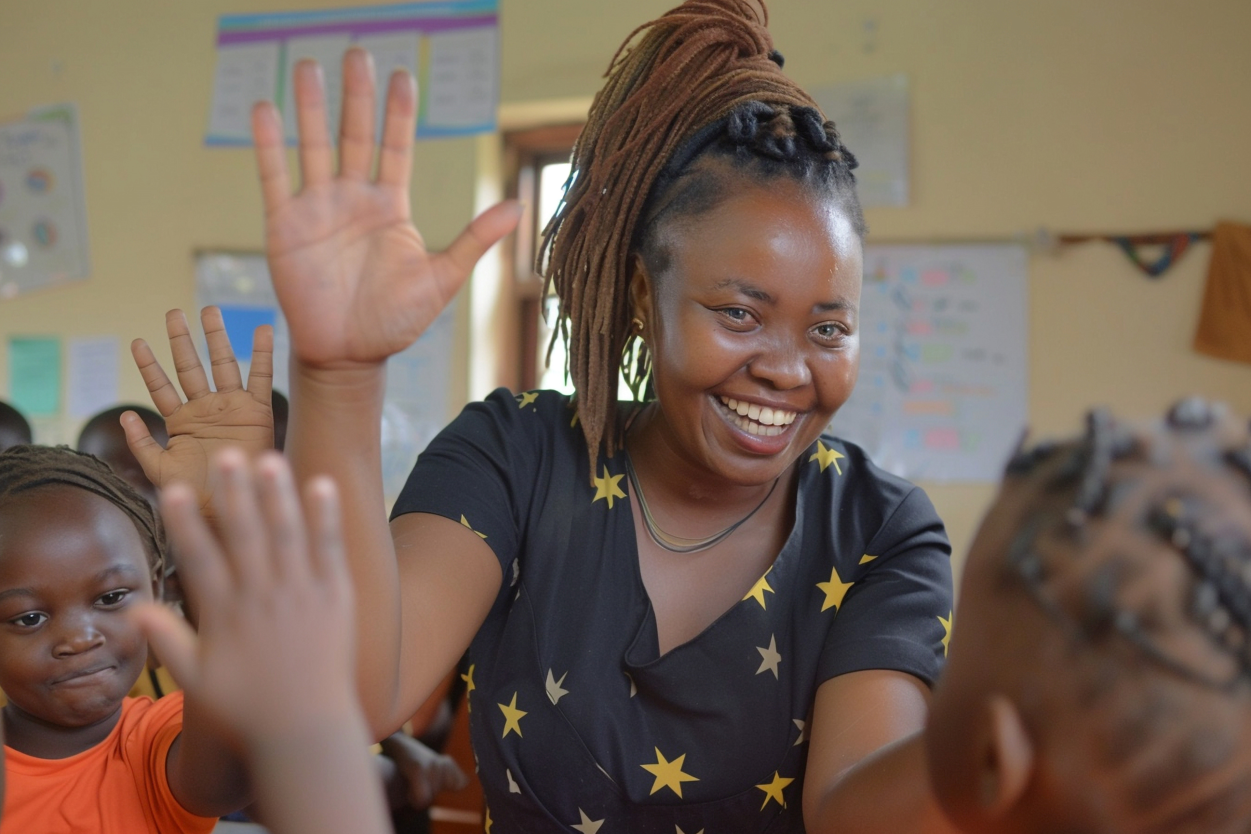 Teacher engaging with raised-hand students